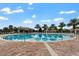 Community pool featuring a large pool, multiple cabanas, and palm trees at 9075 Dogleg Dr, Davenport, FL 33896