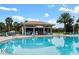 Gorgeous community pool area with poolside bar and plenty of lounge chairs for residents to enjoy at 9075 Dogleg Dr, Davenport, FL 33896