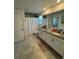 Bathroom with double sinks, tile floors, white cabinets and a shower with white curtain at 11312 Listening Dr, Orlando, FL 32832