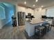 Bright kitchen showcasing an island with seating, stainless steel appliances, and wood-look flooring at 11312 Listening Dr, Orlando, FL 32832