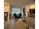 Open-concept living area featuring modern furnishings, a dining table, and neutral decor at 11312 Listening Dr, Orlando, FL 32832