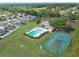 Aerial view of community pool, tennis court and playground, and well-manicured landscaping at 107 Troon Cir, Davenport, FL 33897