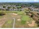 Aerial view of a community with a pool, tennis court and well-manicured landscaping near a golf course at 107 Troon Cir, Davenport, FL 33897