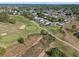 Aerial view of a community with a pool, tennis court and well-manicured landscaping near a golf course at 107 Troon Cir, Davenport, FL 33897