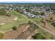 Aerial view of a community with a pool, tennis court and well-manicured landscaping at 107 Troon Cir, Davenport, FL 33897