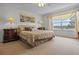 This bedroom features neutral carpeting, a ceiling fan, and a large window that allows for beautiful natural light at 107 Troon Cir, Davenport, FL 33897