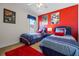 Bedroom with patriotic decor featuring two beds, red walls, and a window that provides natural light at 107 Troon Cir, Davenport, FL 33897