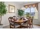 Formal dining room featuring elegant wood furniture and a window with a view to the yard at 107 Troon Cir, Davenport, FL 33897