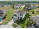 Two-story home with lush landscaping, two-car garage, and a bright red front door at 107 Troon Cir, Davenport, FL 33897