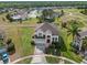 Two-story home boasts lush landscaping, attached two-car garage, and a vibrant red front door at 107 Troon Cir, Davenport, FL 33897