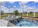 Inviting screened-in patio featuring a rejuvenating hot tub and comfortable lounge chairs overlooking scenic views at 107 Troon Cir, Davenport, FL 33897