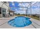 Relaxing screened-in pool area with a sparkling blue pool, patio furniture, and views of the expansive backyard at 107 Troon Cir, Davenport, FL 33897