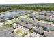 A serene view of a lakeside community featuring homes with modern architecture and lush greenery at 11473 Listening Dr, Orlando, FL 32832