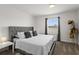 Serene bedroom showcasing a gray tufted headboard and bright natural light from the window at 11473 Listening Dr, Orlando, FL 32832