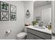 Charming half-bathroom with modern vanity, decorative mirror, and stylish wall art exudes a fresh, clean aesthetic at 11473 Listening Dr, Orlando, FL 32832