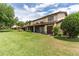 Spacious backyard with lush green grass, mature trees, a cozy patio and well-kept landscaping at 117 Coventry Ln, Haines City, FL 33844