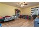 Bedroom with two beds, wood floors, ceiling fan and a bright yellow painted wall at 117 Coventry Ln, Haines City, FL 33844