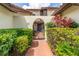 Close up of a home's arched gateway, framed by lush greenery and a stone pathway at 117 Coventry Ln, Haines City, FL 33844