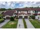 Aerial view of townhomes with manicured lawns, mature trees, and two car garages at 117 Coventry Ln, Haines City, FL 33844