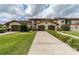 Exterior view of a home showcasing its lush lawn, meticulously trimmed hedges, and convenient two-car garage at 117 Coventry Ln, Haines City, FL 33844