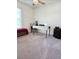 Bright bedroom featuring plush gray carpeting, a ceiling fan, and a dedicated desk area for work or study at 1241 Denali Dr, Winter Haven, FL 33881