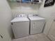Well-equipped laundry area with modern washer and dryer, and shelving for storage and organization at 1241 Denali Dr, Winter Haven, FL 33881