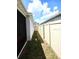 Narrow yard space with lush green grass and white fence, providing a cozy and private outdoor area at 1241 Denali Dr, Winter Haven, FL 33881