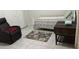 Cozy bedroom with a comfortable recliner and a decorative rug on tile flooring at 133 Bianca Ct, Kissimmee, FL 34758