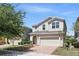 Two-story home with a brick driveway, a two-car garage, and well-maintained landscaping in a sunny setting at 1338 Riley Cir, Deland, FL 32724