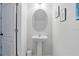 Cozy powder room with pedestal sink, oval mirror, and neutral wall color at 1338 Riley Cir, Deland, FL 32724