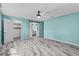 Bedroom featuring sleek flooring, a ceiling fan, barn door, and closet access at 13959 Marine Dr, Orlando, FL 32832