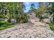 Beautiful home exterior with a long driveway, lush landscaping, and a detached garage at 13959 Marine Dr, Orlando, FL 32832
