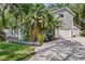 Charming home featuring two garages, lush tropical landscaping, and a welcoming gray wood finish at 13959 Marine Dr, Orlando, FL 32832