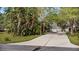 Inviting home exterior with lush tropical plants, mature trees, and a long driveway at 13959 Marine Dr, Orlando, FL 32832