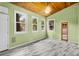 Green-walled room with wood ceiling and ample windows offering natural light and views of the backyard at 13959 Marine Dr, Orlando, FL 32832