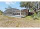 Backyard screened-in pool featuring a large enclosure, clean pool and landscaping at 1730 King Henry Dr, Kissimmee, FL 34744