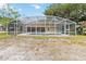 Backyard screened-in pool featuring a large enclosure, clean pool and landscaping at 1730 King Henry Dr, Kissimmee, FL 34744