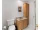 Bathroom featuring a marble countertop vanity with a sink, toilet and wooden storage cabinet at 1730 King Henry Dr, Kissimmee, FL 34744