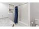 Bright bathroom featuring a shower and tub combo, a window and marble countertops at 1730 King Henry Dr, Kissimmee, FL 34744