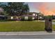Charming two-story home with manicured lawn, lush landscaping, and brick mailbox on a sunny day at 1730 King Henry Dr, Kissimmee, FL 34744