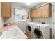 Bright laundry room with front loading washer and dryer, utility sink and ample cabinet storage space at 1730 King Henry Dr, Kissimmee, FL 34744