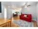 This bright living room features wood floors, a red sofa, and seamless flow into the dining and kitchen areas at 1730 King Henry Dr, Kissimmee, FL 34744