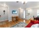 Cozy living room boasts wood floors, a ceiling fan, natural light, and a vibrant red sofa, perfect for relaxation at 1730 King Henry Dr, Kissimmee, FL 34744