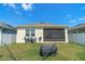 Spacious backyard features a screened-in patio, a grill, and lawn at 1774 Walnut Creek Dr, Kissimmee, FL 34744