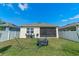 Well-maintained backyard featuring a screened-in patio and a pristine white fence at 1774 Walnut Creek Dr, Kissimmee, FL 34744
