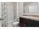 Bathroom featuring a shower-tub combo with stylish curtain and a vanity with dark cabinetry at 1774 Walnut Creek Dr, Kissimmee, FL 34744