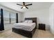 Comfortable bedroom with a dark wood bed frame, a ceiling fan, and a large window at 1774 Walnut Creek Dr, Kissimmee, FL 34744