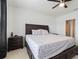 Comfortable bedroom features a dark wood bed frame, a ceiling fan, and a nightstand at 1774 Walnut Creek Dr, Kissimmee, FL 34744