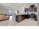 Open-concept kitchen with dark wood cabinets, stainless steel appliances, and a breakfast bar overlooking the living space at 1774 Walnut Creek Dr, Kissimmee, FL 34744