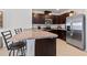 Well-equipped kitchen featuring dark cabinetry, stainless steel appliances, tile flooring and a breakfast bar at 1774 Walnut Creek Dr, Kissimmee, FL 34744